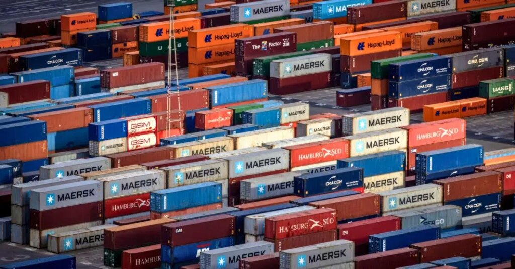 Shipping containers at a port symbolizing trade disruption fears among US exporters reacting to Trump's proposed 30 percent tariff.